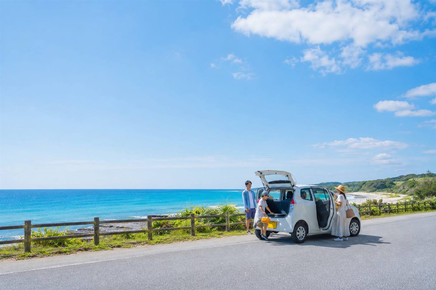 海辺でくつろぐ家族とレンタカー